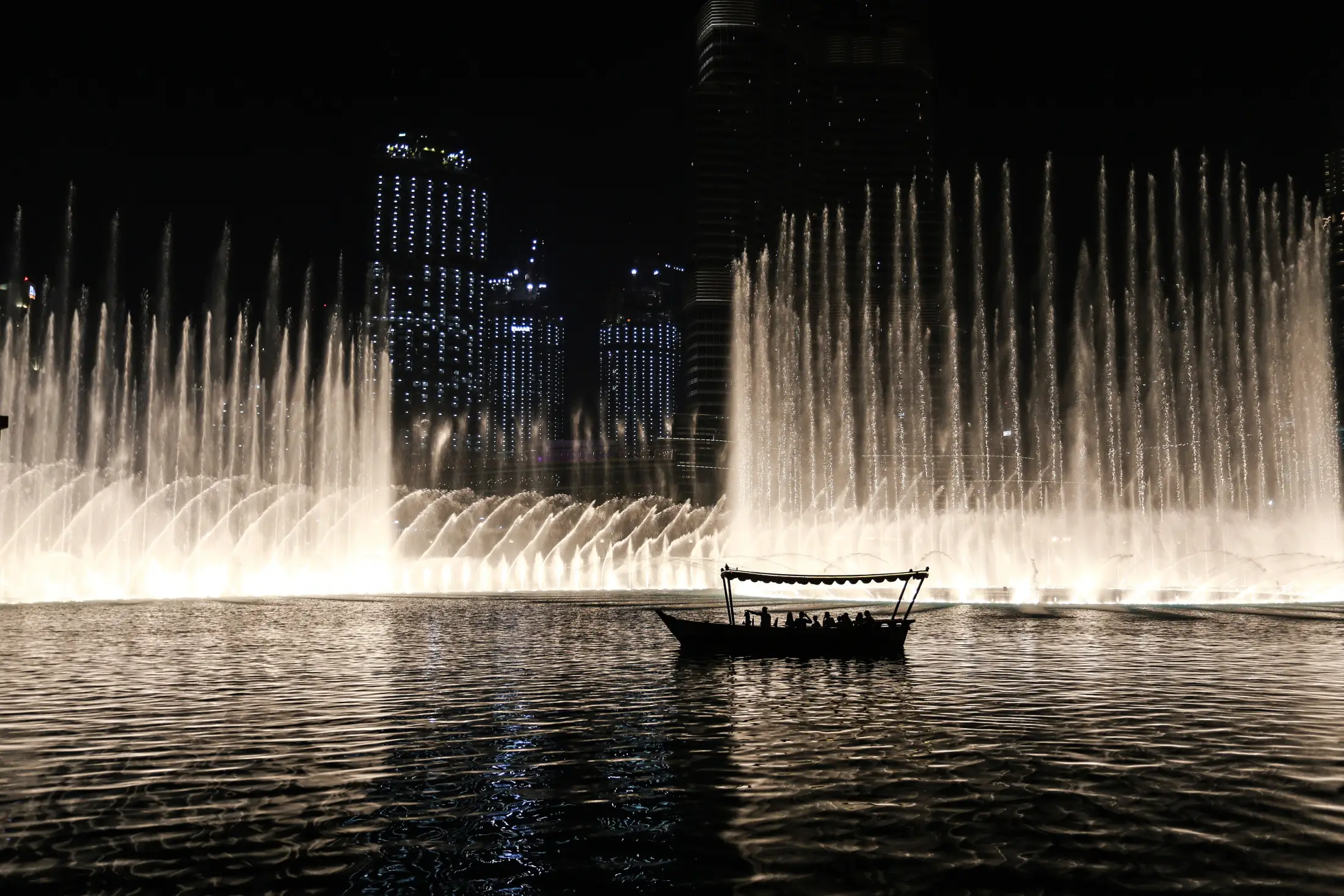 A lone abra on the lake beneath the Dubai Fountain